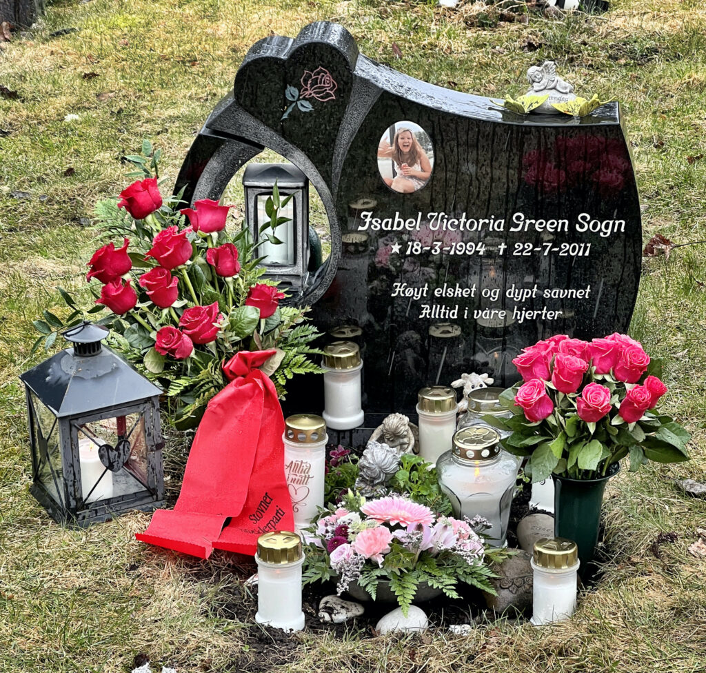Bilde av Isabel Victoria Green Sogns gravstein. En masse blomster, lykter og gravlys er plassert foran gravsteinen, deriblant en bårebukett fra Stovner Arbeiderparti.